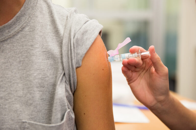 A nursing senior from TCU Nursing administers a flu vaccine to another student during the TCU Flu Clinic.