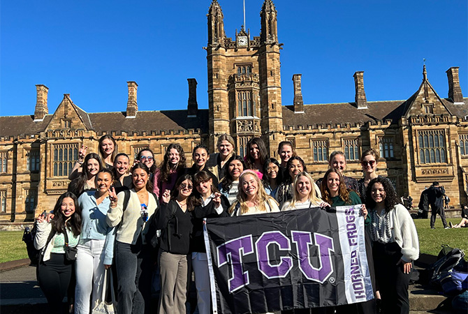  graduate speech-language pathology students in Australia holding a TCU flag